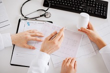 healthcare, hospital and medical concept - two doctors prescribing medication